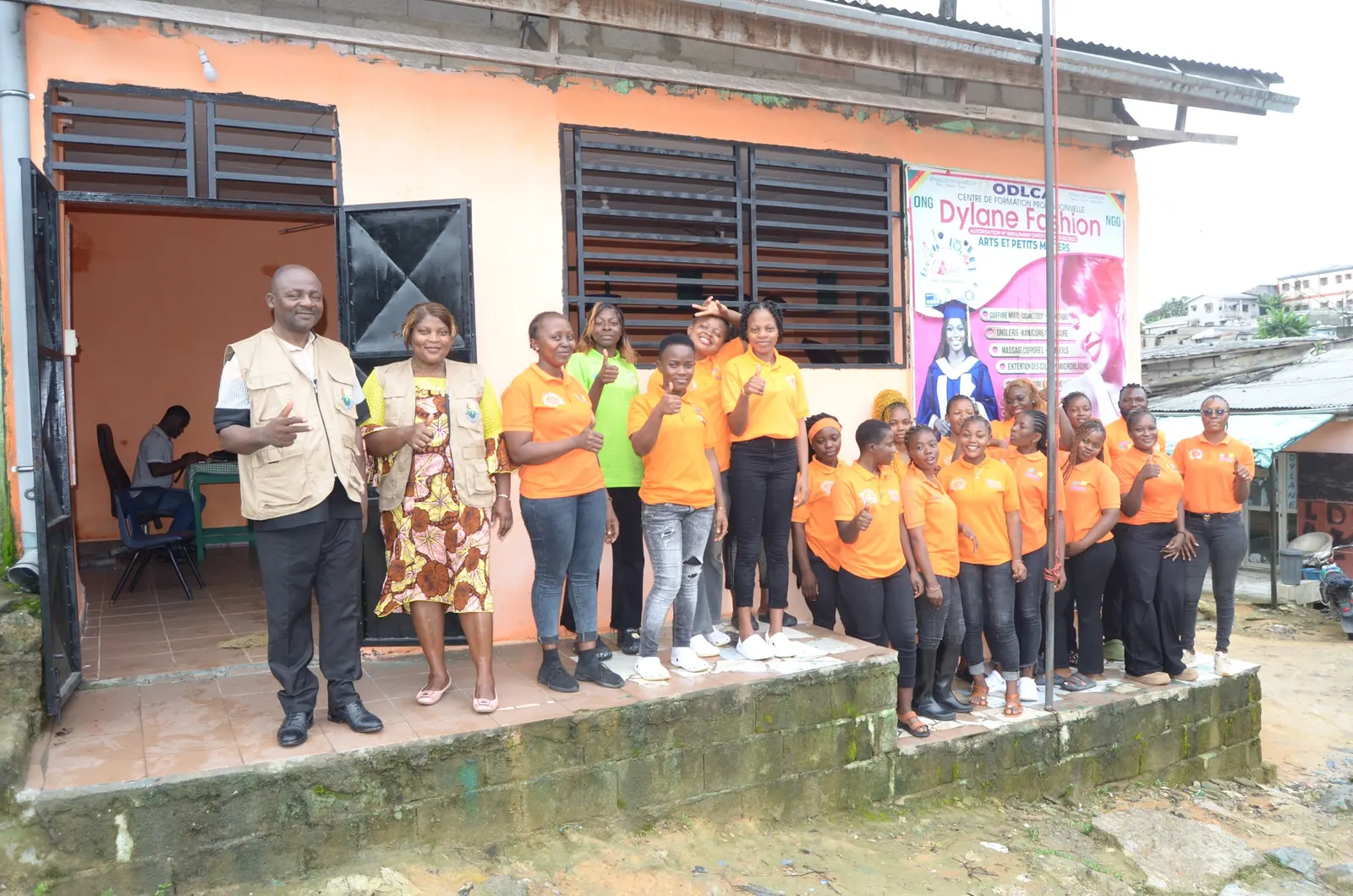 Des jeunes accompagnés par Afrique Charité devant leur centre de formation, au Cameroun