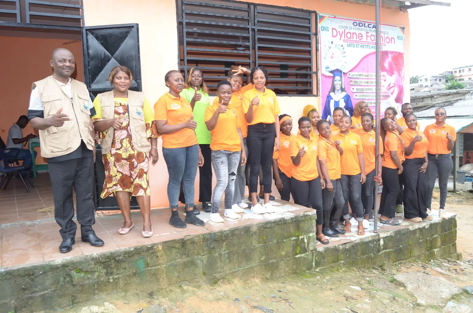 Des jeunes accompagnés par Afrique Charité devant leur centre de formation, au Cameroun