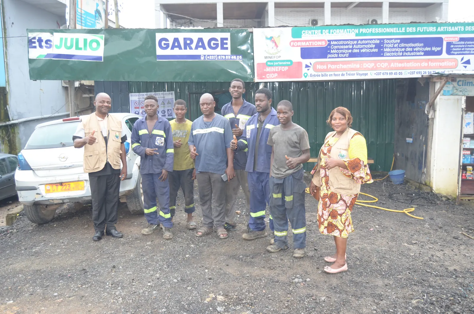 Des apprentis mécaniciens devant un garage, au Cameroun